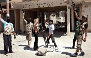 Rebeldes sírios festejam enquanto preparam lançamento de um rocket contra forças leais ao presidente Bashar al-Assad