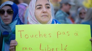 Uma manifestante segura um cartaz pedindo que ninguém toque na sua liberdade, durante um protesto em Montreal contra a proposta de Carta de Valores pelo Parti Québécois - 29 de setembro, 2013. (Peter McCabe / The Canadian Press)
