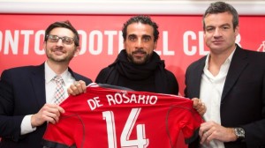 Tim Bezbatchenko, diretor-geral do Toronto FC, Dwayne De Rosario, ao centro, e Ryan Nelsen, o treinador do Toronto FC, posam para uma fotografia, na quinta-feira, 9 de janeiro, 2014. (The Canadian Press/Nathan Denette)