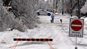 Um pedestre caminha por uma rua ainda encerrada por causa de linhas de eletricidade derrubadas e árvores, em Brampton, Ontário - 23 de dezembro de 2013. (The Canadian Press / JP Moczulski)