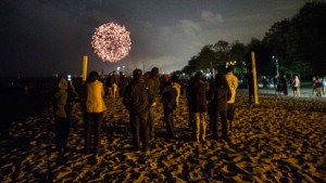 Uma família observa o fogo de artifício do Victoria Day em Toronto, na praia - 20 de maio de 2013. (Chris Young/The Canadian Press)