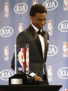 Andrew Wiggins sorri quando passa pelo seu troféu, durante um anúncio de que ele era o Rookie do Ano da NBA, em Minneapolis - 30 de abril de 2015. (AP / Jim Mone)