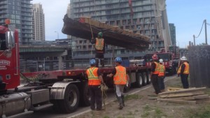 Os restos de escuna incompletos foram cuidadosamente levantados por um guindaste e carregados num camião para serem levados para o Fort York. (Kira Wakeam / CBC)