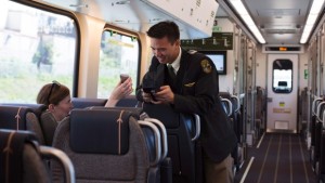 Um passageiro vê o seu bilhete digitalizado durante a nova ligação ferroviária do expresso da estação Union para o aeroporto Pearson de Toronto - 6 de junho de 2015. The Canadian Press / Michelle Siu
