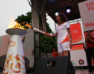 Momento em que Amanda Martinez acende a pira instalada no cimo do palco. LA/CMC
