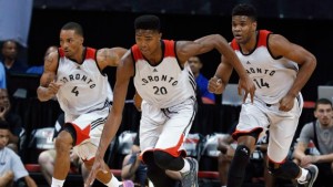 Bruno Caboclo, centro, dos Toronto Raptors e os companheiros de equipa Norman Powell, à esquerda, e Ronald Roberts, durante a primeira metade de um jogo de basquetebol da liga de verão da NBA contra os Sacramento Kings em Las Vegas - 10 de julho de 2015. (AP / John Locher)
