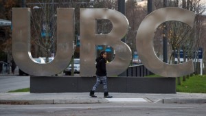 Uma jovem rapariga passa pelas grandes letras que soletram UBC na Universidade da Colúmbia Britânica, em Vancouver, B.C. - 22 de novembro de 2015. (The Canadian Press / Darryl Dyck)