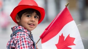 Sam Kashfi, de três anos de idade, sorri durante o desfile anual do dia do Canadá em Montreal, 1 de julho de 2015. (Graham Hughes / The Canadian Press)