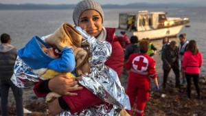Uma mulher síria segura o seu bebé após a sua chegada num pequeno barco a partir da costa turca no Nordeste da ilha grega de Lesbos - 16 de novembro, 2015. (AP / Santi Palacios)