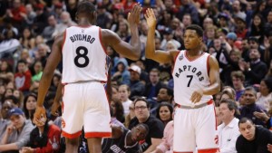 Kyle Lowry, dos Toronto Raptors e Bismack Biyombo comemoram mais uma marcação de pontos contra os Orlando Magic durante a segunda parte do jogo de basquetebol da NBA, em Toronto - 20 de março de 2016. (Mark Blinch/The Canadian Press)