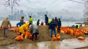 Dezenas de moradores da Ilha de Toronto instalam sacos de areia como barricadas para proteger a infraestrutura da ilha (Travis Dhanraj / CP24)