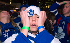 Fãs dos Toronto Maple Leafs reagem ao quarto golo dos Boston Bruins, enquanto assistiam (ontem) ao terceiro período do jogo 7 dos playoffs NHL, na Maple Leafs Square, em Toronto. (The Canadian Press/Frank Gunn)