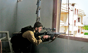 Um atirador furtivo do Exército Livre da Síria (rebeldes) em posição numa casa abandonada no distrito de Idlib, na Síria