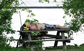 Um homem tira uma soneca debaixo de uma sombra, na praia de Sunnyside, no Lago Ontário, em Toronto, 8 de junho de 2011. (The Canadian Press/Nathan Denette).