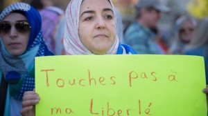 Uma manifestante segura um cartaz pedindo que ninguém toque na sua liberdade, durante um protesto em Montreal contra a proposta de Carta de Valores pelo Parti Québécois -  29 de setembro, 2013. (Peter McCabe / The Canadian Press)