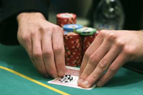 Um jogador verifica a sua mão durante um jogo de Texas Hold 'em, na sala de poker no Caesar's Palace - 27 fevereiro de 2013, em Las Vegas. AP / Julie Jacobson