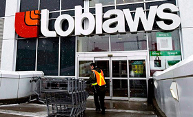 Um funcionário do Loblaws arruma os carrinhos de compras. (The Canadian Press / Nathan Denette)