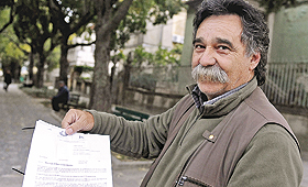 Albino Ribeiro exibe a carta que recebeu da Segurança Social a exigir o pagamento. (EDGAR MARTINS)