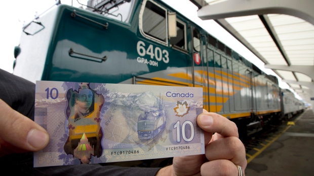 A nova nota de polímero de dez dólares é retratada na frente do comboio que está impresso na nota - estação central de comboios, em Vancouver, BC, na quinta-feira, 7 de novembro, 2013. (The Canadian Press / Jonathan Hayward)