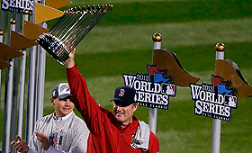 O manager dos Boston Red Sox, John Farrell, ergue o troféu do campeonato depois de vencer a World Series em Boston. (AP Photo / Chris Carlson)