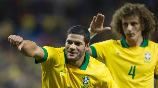Hulk do Brasil comemora após ter marcado o golo inaugural contra o Chile, com o companheiro de equipa, David Luiz (The Canadian Press / Chris Young)