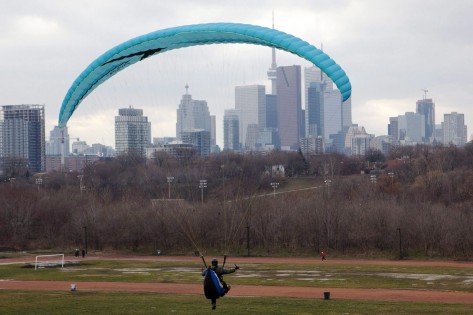 O horizonte de Toronto é visto, por trás de um praticante de parapente. THE CANADIAN PRESS/Pawel Dwulit