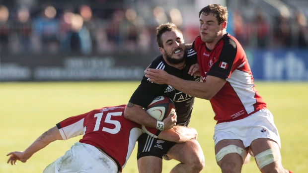 O neozelandês Andre Taylor (Maori All Black), centro, é travado pelo canadiano Matt Evans, à esquerda, e Aaron Carpenter, durante a segunda parte do jogo de râguebi, em Toronto - domingo, 3 de novembro, 2013. (The Canadian Press / Chris Young)