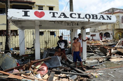 Os moradores estão rodeados por um monte de destroços depois da passagem do tufão Haiyan em Tacloban, na província de Leyte, região central das Filipinas - 10 de novembro de 2013. AFP / Getty Images / Ted Aljibe