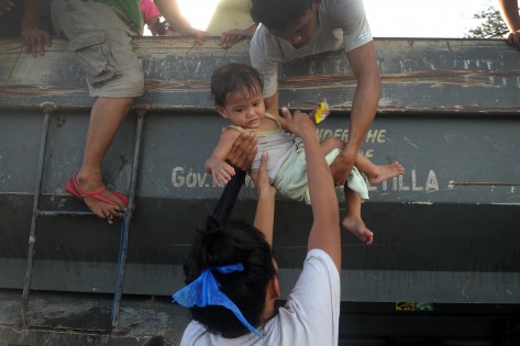 Moradores regressam às suas casas depois de saírem de um local de evacuação, após a passagem do Tufão Haiyan, em Tacloban, Leyte – foto de arquivo. AFP / Getty Images / Noel Celis