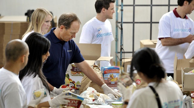 O CEO da Citi Canada, John Hastings, ajuda alguns dos seus 80 funcionários a separar os alimentos, no Daily Bread Food Bank, em Toronto. Foto de arquivo. (Citi / The Canadian Press)