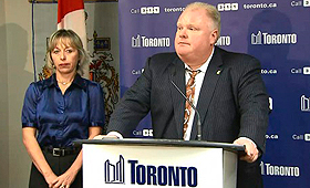 Rob Ford fala com os repórteres na Câmara de Toronto, com a sua esposa Renata atrás. Foto de arquivo: CityNews