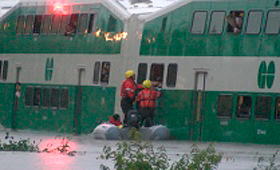 Passageiros retidos são resgatados de um comboio GO inundado. 8 de julho de 2013.