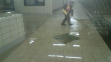 Um trabalhador limpa a água na Yonge-Bloor Station. (Twitter / TTC)