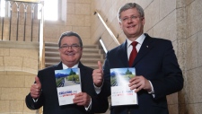 Jim Flaherty e o primeiro-ministro Stephen Harper entram na Câmara dos Comuns, no dia da apresentação do orçamento no Parliament Hill em Ottawa. (The Canadian Press / Patrick Doyle)