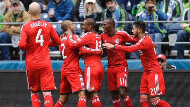 Jermain Defoe (Toronto FC), centro, comemora com os companheiros de equipa, depois de marcar o primeiro de dois golos, durante a partida de futebol (soccer) da MLS contra os Seattle Sounders. (AP Photo / Ted S. Warren)