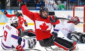 Billy Bridges do Canadá comemora o seu golo durante a partida de hóquei de gelo (sledge) entre o Canadá e a Noruega(AP Photo / Pavel Golovkin)