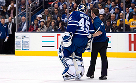 O guarda-redes dos Toronto Maple Leafs, Jonathan Bernier, é ajudado para sair fora do rinque depois de ter sofrido uma lesão durante o terceiro período de ação no jogo contra os Boston Bruins (NHL) em Toronto - 3 de abril de 2014. (The Canadian Press / Frank Gunn)
