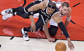 Paul Pierce, dos Brooklyn Nets, à esquerda, e Jonas Valanciunas, dos Toronto Raptors, lutam pela posse da bola durante o primeiro jogo do playoff da NBA em Toronto - 19 de abril de 2014. (THE CANADIAN PRESS/Darren Calabrese)