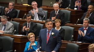 O ministro das Finanças do Ontário Charles Sousa, ao centro, apresenta o orçamento 2014, ao lado da primeira-ministra Kathleen Wynne, no Queen’s Park, em Toronto - 1 de maio, 2014. (The Canadian Press/Nathan Denette)