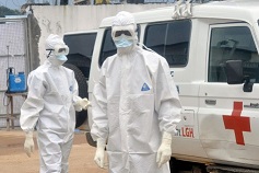 Profissionais de saúde usando equipamento de proteção aguardam para transportar o corpo de uma pessoa suspeita de ter morrido de Ébola, em Monróvia, na Libéria - 13 de outubro de 2014. Associated Press / Abbas Dulleh