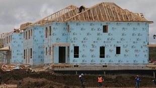 Um trabalhador da construção trabalha numa casa num novo conjunto habitacional em Oakville, Ontário, nesta foto de arquivo. (The Canadian Press / Richard Buchan)
