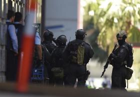 IMAGENS TELEVISIVAS MOSTRAM TRÊS REFÉNS A SAIR DE CAFÉ DE SYDNEY