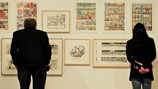 Bob e Tina Denison leem histórias aos quadrinhos de Art Spiegelman, durante a exposição 
