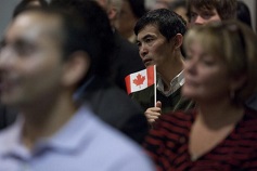 Um novo cidadão canadiano segura uma bandeira do Canadá, durante uma cerimónia de cidadania em Otava. Foto de arquivo. The Canadian Press / Pawel Dwulit