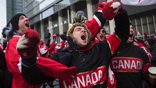 Os fãs de hóquei no gelo comemoram quando Chris Kunitz marca o terceiro golo do Canadá, na final olímpica, na Maple Leaf Square de Toronto - 23 de fevereiro de 2014. O Canadá derrotou a Suécia por 3-0, vencendo a medalha de ouro. The Canadian Press / Chris Young
