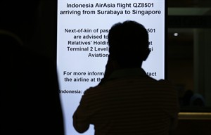 Um homem lê as intruções de uma placa de sinal eletrónico numa área de espera no Aeroporto International de Changi, relacionadas com o voo 8501 da AirAsia. (AP Photo / Wong Maye-E)