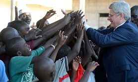 Um grupo de jovens cumprimentam o primeiro-ministro Stephen Harper quando este chega para visitar a Clínica de Saúde Bargny, em Bargny, Senegal, no domingo, 30 de novembro de 2014. The Canadian Press/Sean Kilpatrick