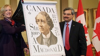 A ministra dos Transportes Lisa Raitt e o CEO da Canada Post, Deepak Chopra, participam na inauguração de um selo de Sir John A. Macdonald, durante uma cerimónia na Câmara Municipal de Kingston para marcar o bicentenário do nascimento do primeiro Primeiro-Ministro do Canadá, em Kingston, Ontário. (The Canadian Press/Fred Chartrand)