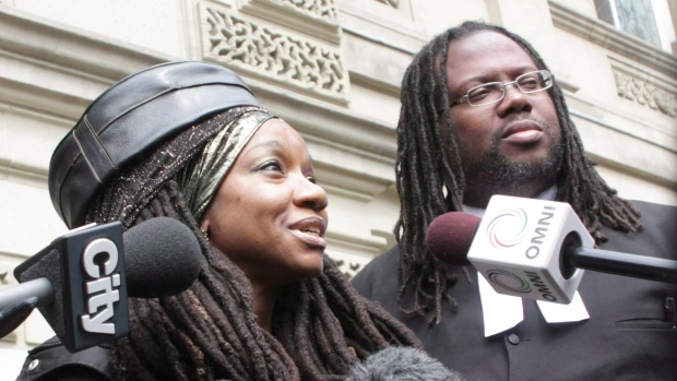 A cidadã jamaicana Simone Topey, acompanhada pelo seu advogado Selwyn Pieters, em 2014, é um dos três residentes permanentes no Canadá que lutaram contra a inclusão no juramento de cidadania de um juramento de fidelidade à Rainha. Topey e os outros perderam o seu caso e o Supremo Tribunal recusou-se a ouvir o seu apelo. (Colin Perkel / Canadian Press)