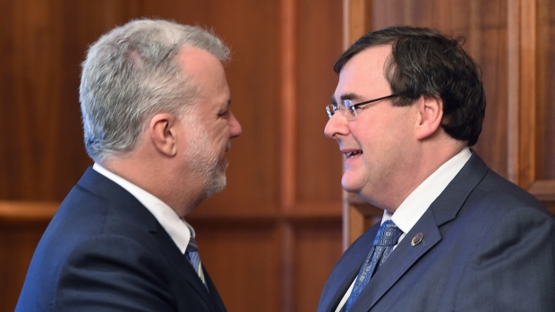 O primeiro-ministro do Quebec, Philippe Couillard, à esquerda, felicita François Blais, o ministro da Ciência, Pesquisa e Ensino, depois que este foi empossado - 27 de fevereiro, 2015, no gabinete do Tenente Governador em Quebec City. (THE Canadian Press / Jacques Boissinot)